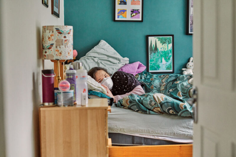 A woman with Long COVID who is completely bedridden, requiring the use of a wheelchair to move between rooms of her home. 