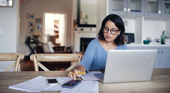 Woman calculating her finances at home