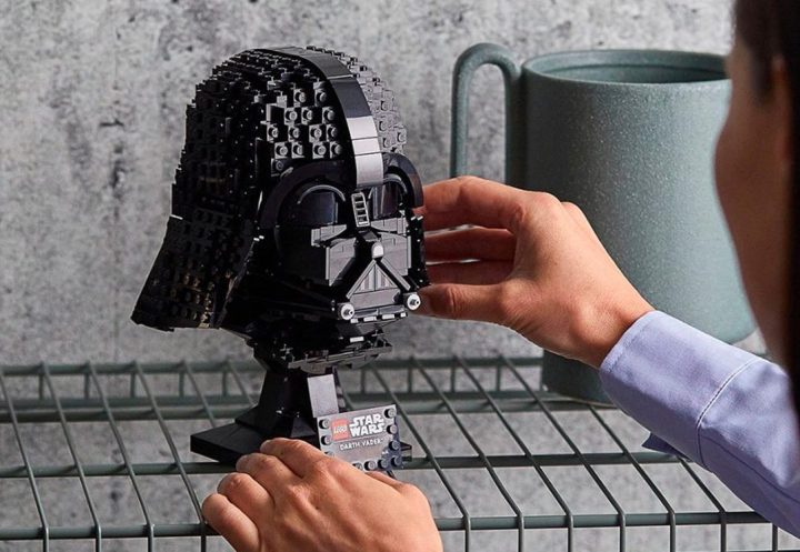 A woman puts the Lego Star Wars Darth Vader Helmet on a shelf.