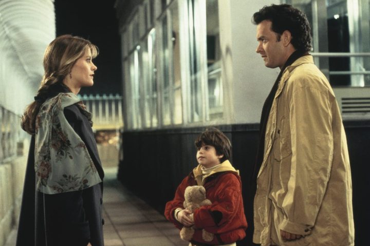 A man next to his son stands in front of a woman in Sleepless in Seattle.