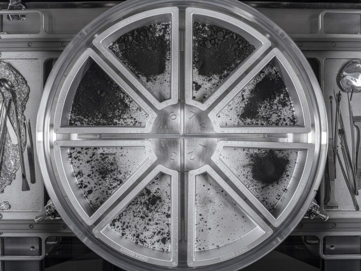 A view of eight sample trays containing the final material from asteroid Bennu. The dust and rocks were poured into the trays from the top plate of the Touch-and-Go Sample Acquisition Mechanism (TAGSAM) head. 51.2 grams were collected from this pour, bringing the final mass of asteroid sample to 121.6 grams.