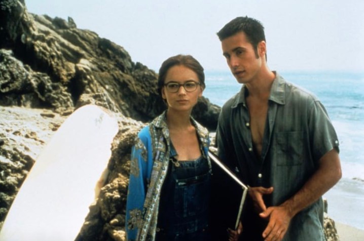 Rachael Leigh Cook and Freddie Prinze Jr.stand next to each other on a beach in She's All That.