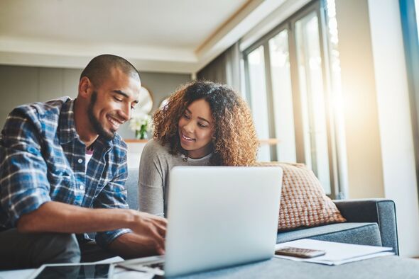 Couple smiling while assessing finances