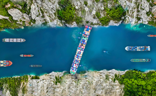 Aerial view/A large cargo ship swept through the waterways in the Suez Canal, making it impossible for other ships to go.