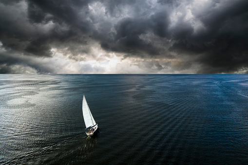 Aerial view of a yacht in a storm with a dramatic sky