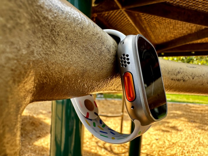 Apple Watch Ultra hanging on playground bar showing the Action Button.