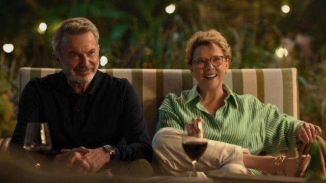 man and woman sit on patio furniture with wine glasses