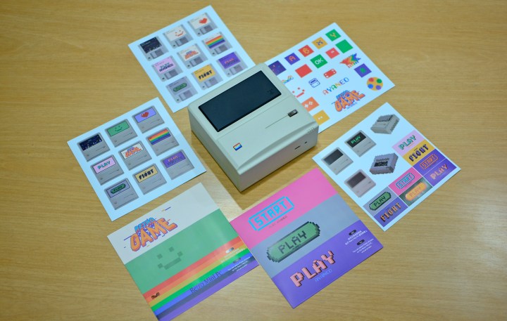 The Ayaneo Retro Mini PC AM01 with all the bundled stickers placed on a desk.