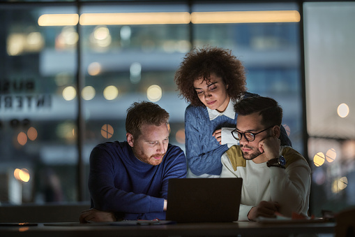 Business team working on a computer late in the office.