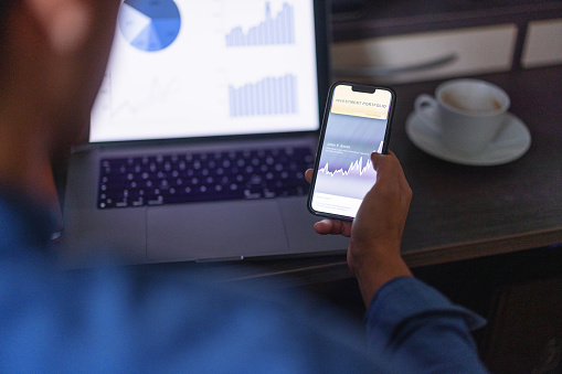 Close up shot of a man checking his investment portfolio on his phone