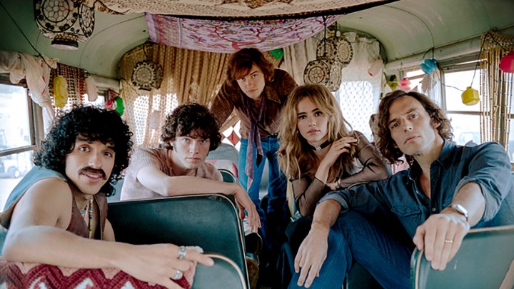 The fictional band from Daisy Jones & The Six posing on a tour bus.