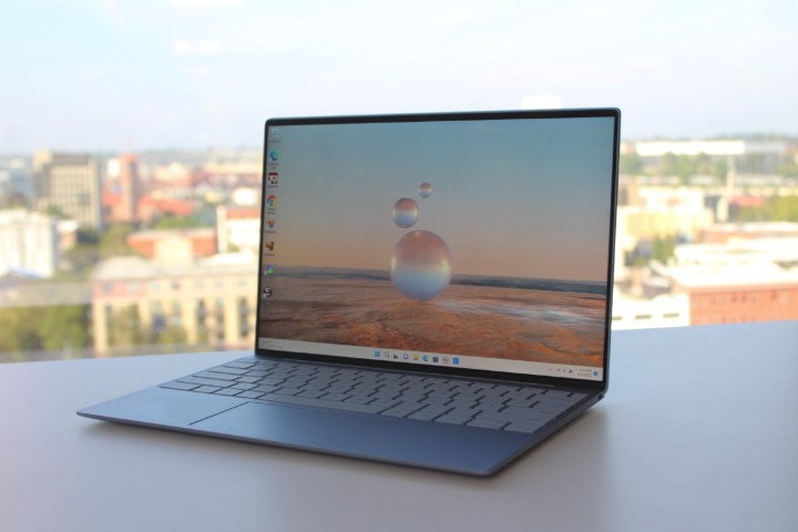 The Dell XPS 13, open on a table in front of a window.