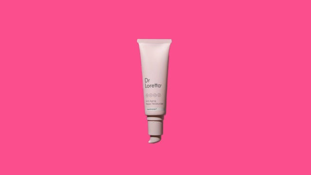 A pink bottle of moisturizer on a pink background