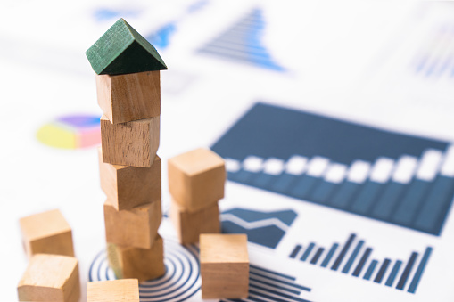 engineer playing a blocks wood tower game (jenga) on blueprint or architectural project,growth concept