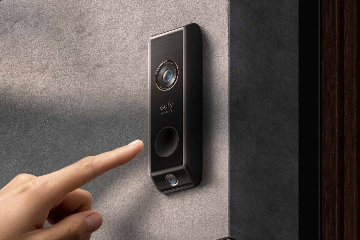 Finger pressing the Eufy Security Video Doorbell Dual.