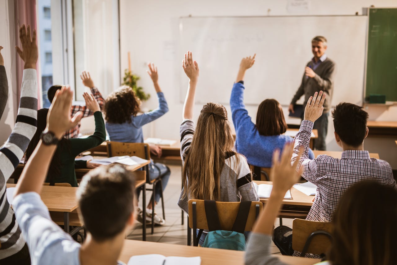 Classroom with students raising their hands