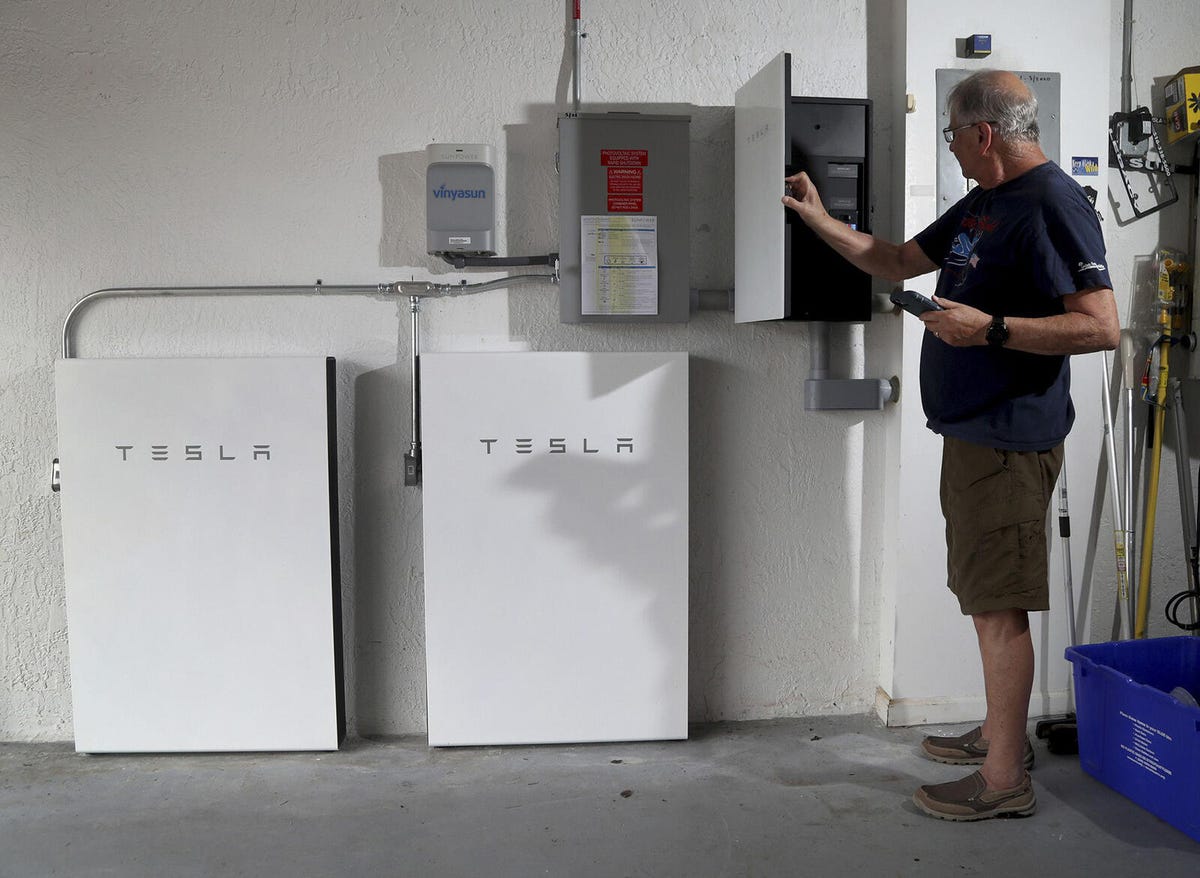 A man checking on his Tesla Powerwall home battery back up system