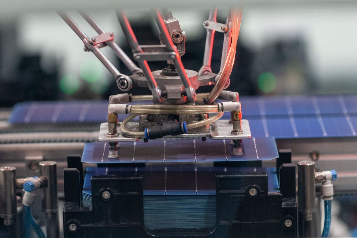 A machine sorts and stacks solar cells for solar panels.