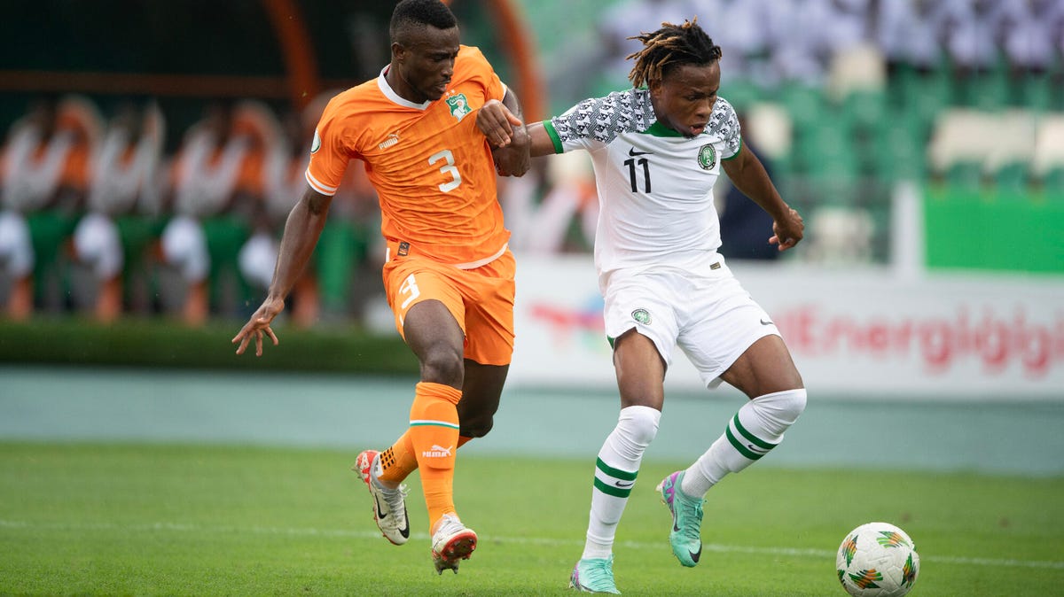 Footballers N'Clomande Ghislain Konan of Ivory Coast and Samuel Chimerenka Chukwueze of Nigeria competing for the ball.