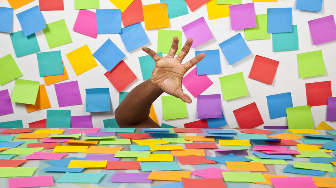 Hand searching among a desk of Postit notes