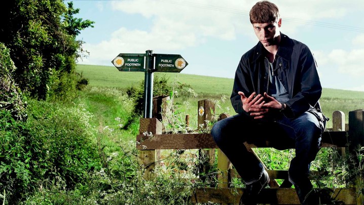 A man sits on a post outside in Glue.