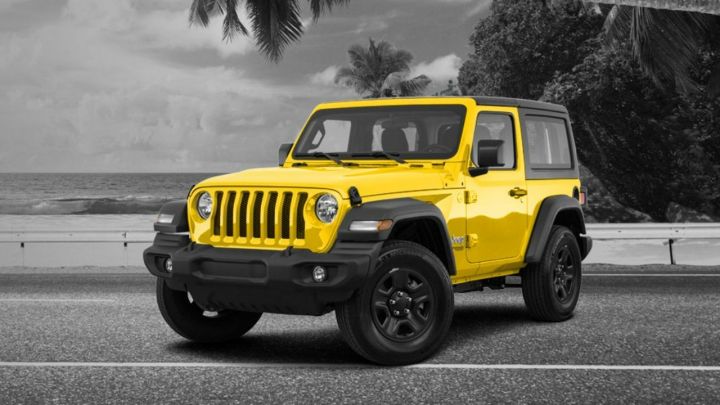 A yellow Jeep on a road.