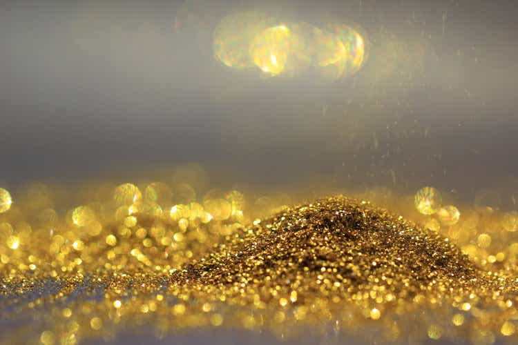 Close up of Sprinkle gold dust and glitter lights on dark background