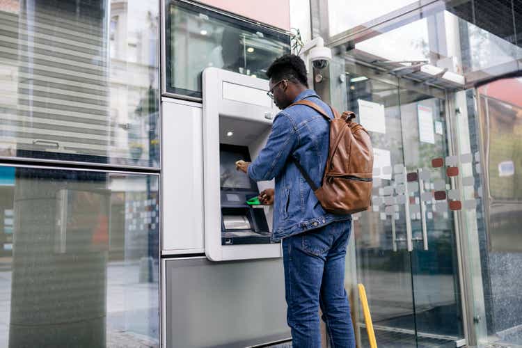 Young man retrieving money from his bank account