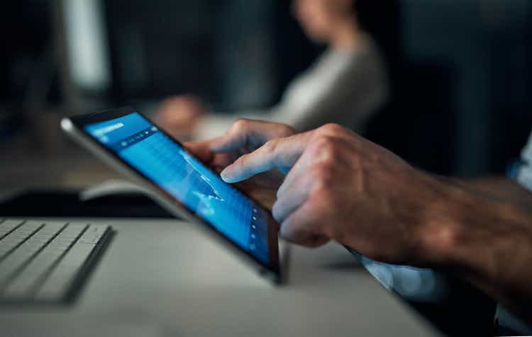 Stock market, investment and tablet trading graph of a business man working in a office. Fintech, cryptocurrency and digital accounting management of a businessman working on online financial wealth