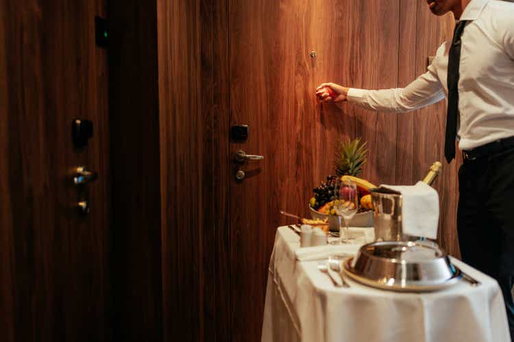 Room service knocking on hotel room door.