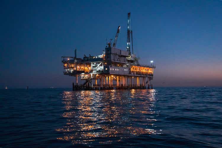 Night Time Offshore Oil Rig Drilling and Fracking Operation, Brightly Lit, on Calm Seas