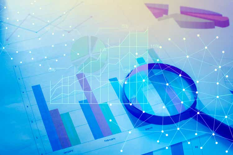 Magnifying glass and documents with analytics data lying on tabl