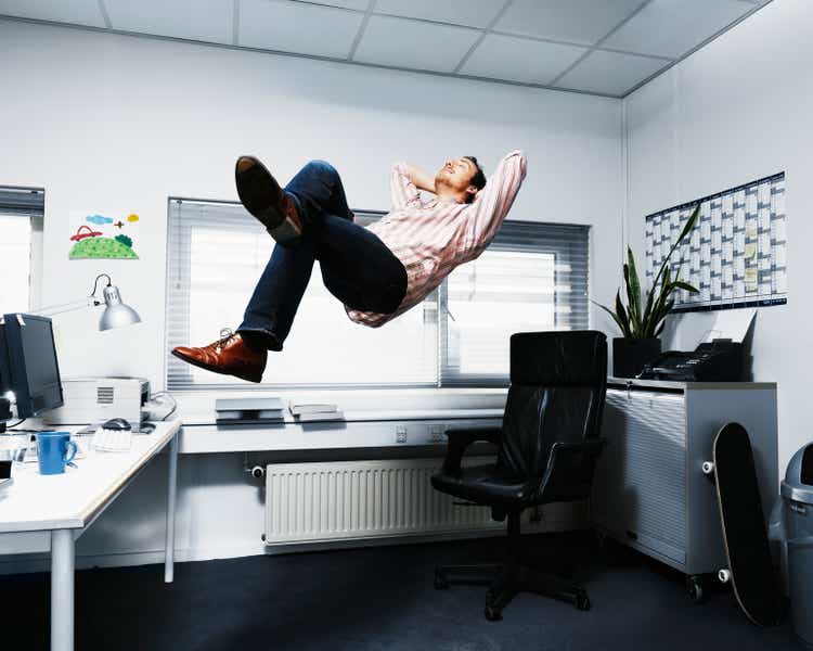 Man Floating in his office.