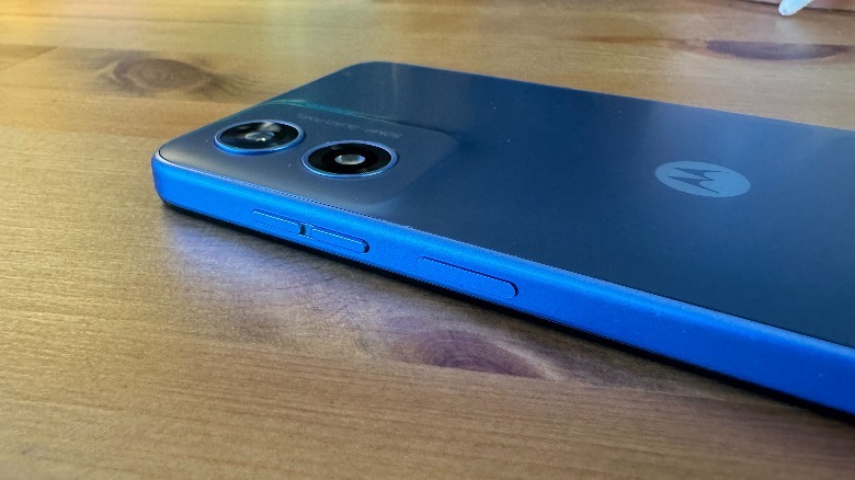 Blue Moto G Play (2024) lying face down on wood surface.