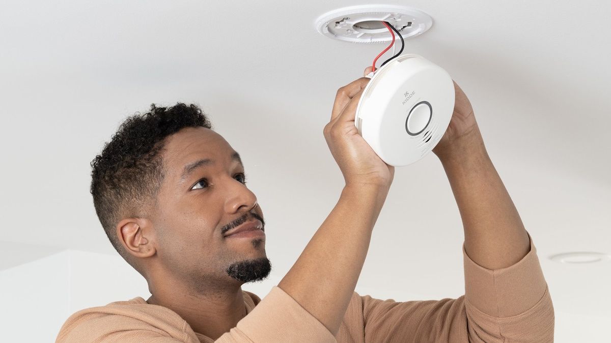 Person setting up Kidde smart smoke detector