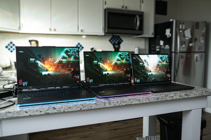 Three Asus laptops set up on a counter.