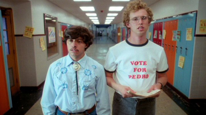 Two boys stand in the hallways of a school.