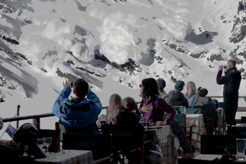 A group of people stare at an avalanche.