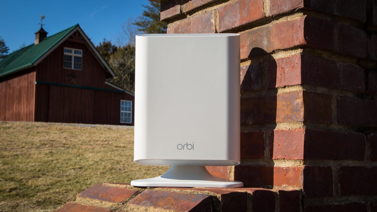 Netgear Orbi Outdoor satellite unit sitting on a brick wall.