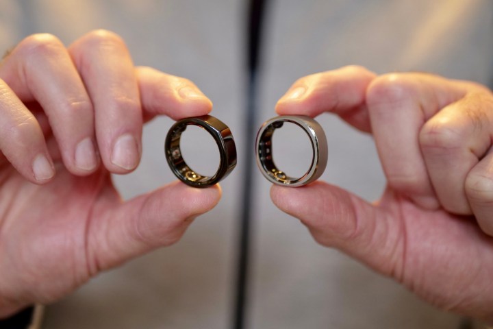 A person holding the RingConn Smart Ring and Oura Ring.