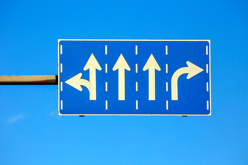 Road sign against blue sky