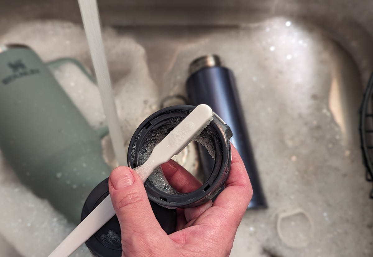 toothbrush cleaning staney cup lid in sink