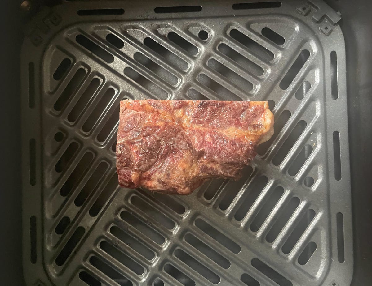 piece of steak in air fryer basket