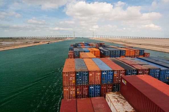 Loaded containers stacked on top of a cargo ship sailing in a canal, Suez Canal, Red sea, Egypt