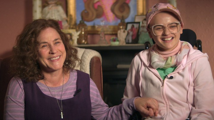 Patricia Arquette and Joey King as Dee Dee and Gypsy Blanchard, sitting together holding hands in a scene from The Act.