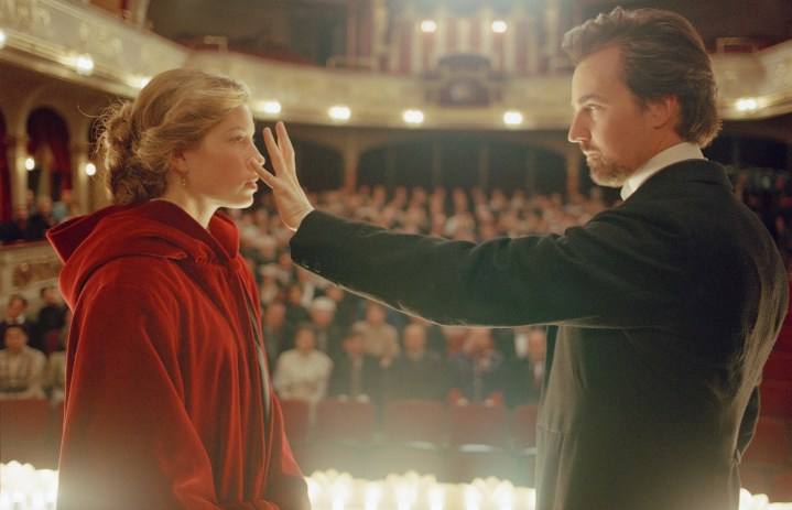 A man performs on stage with a woman in The Illusionist.