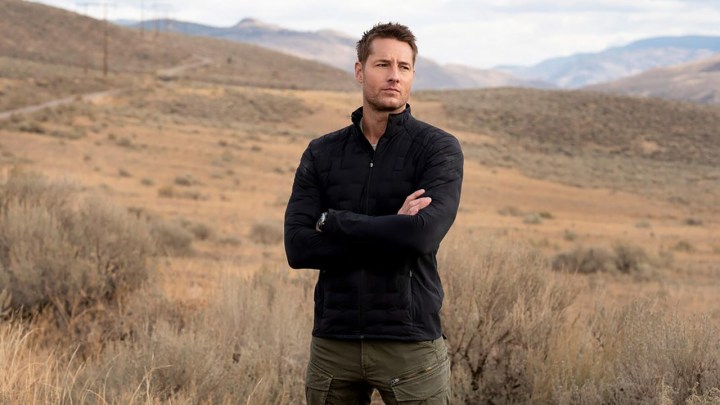 Justin Hartley standing alone in a field in a scene from Tracker.