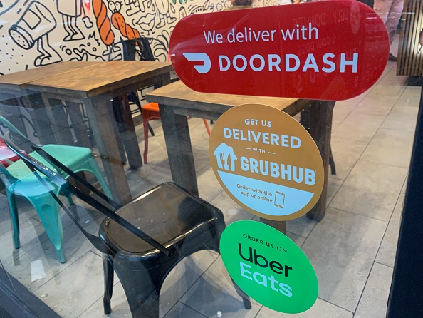 We Deliver, Doordash, Grubhub and Uber Eats signs on restaurant door, New York City