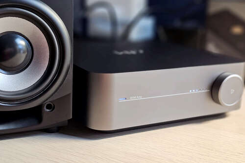 Wiim Amp next to a speaker.