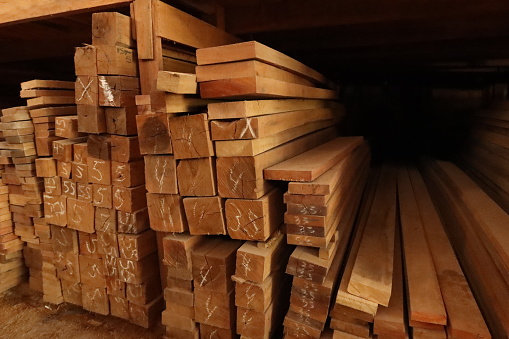 Wood sawn in a lumberyard, slats, boards, pillars stocked in a pile